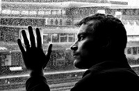 Man gazing out rainy window