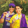 Thumbnail image of two people holding medals up and smiling