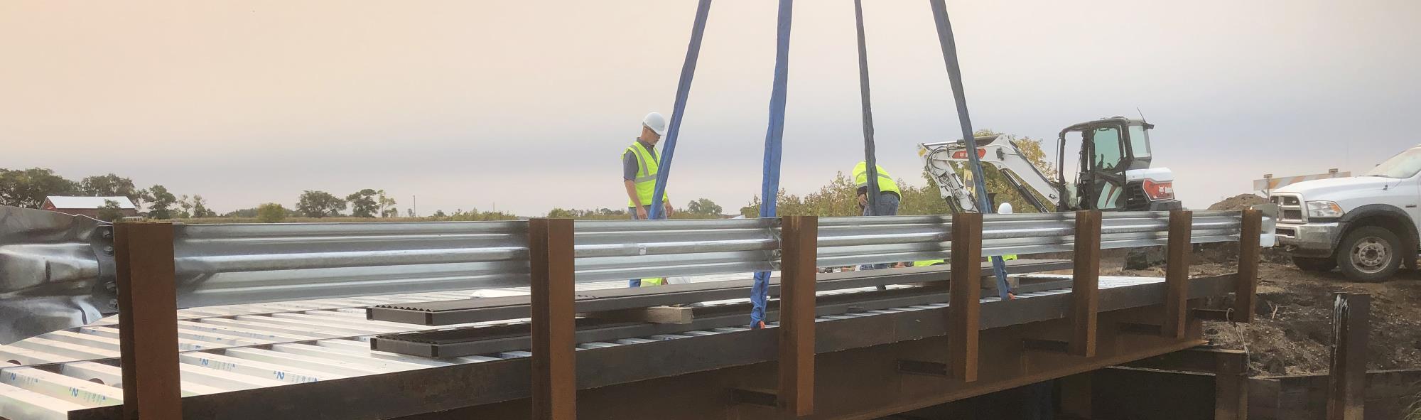 Image of highway department workers dropping a bridge into place