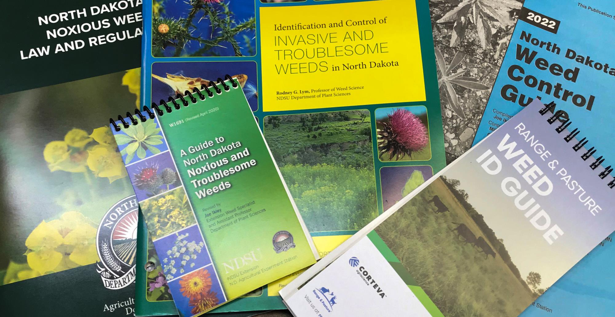 Image of weed control booklets and magazines spread across a table