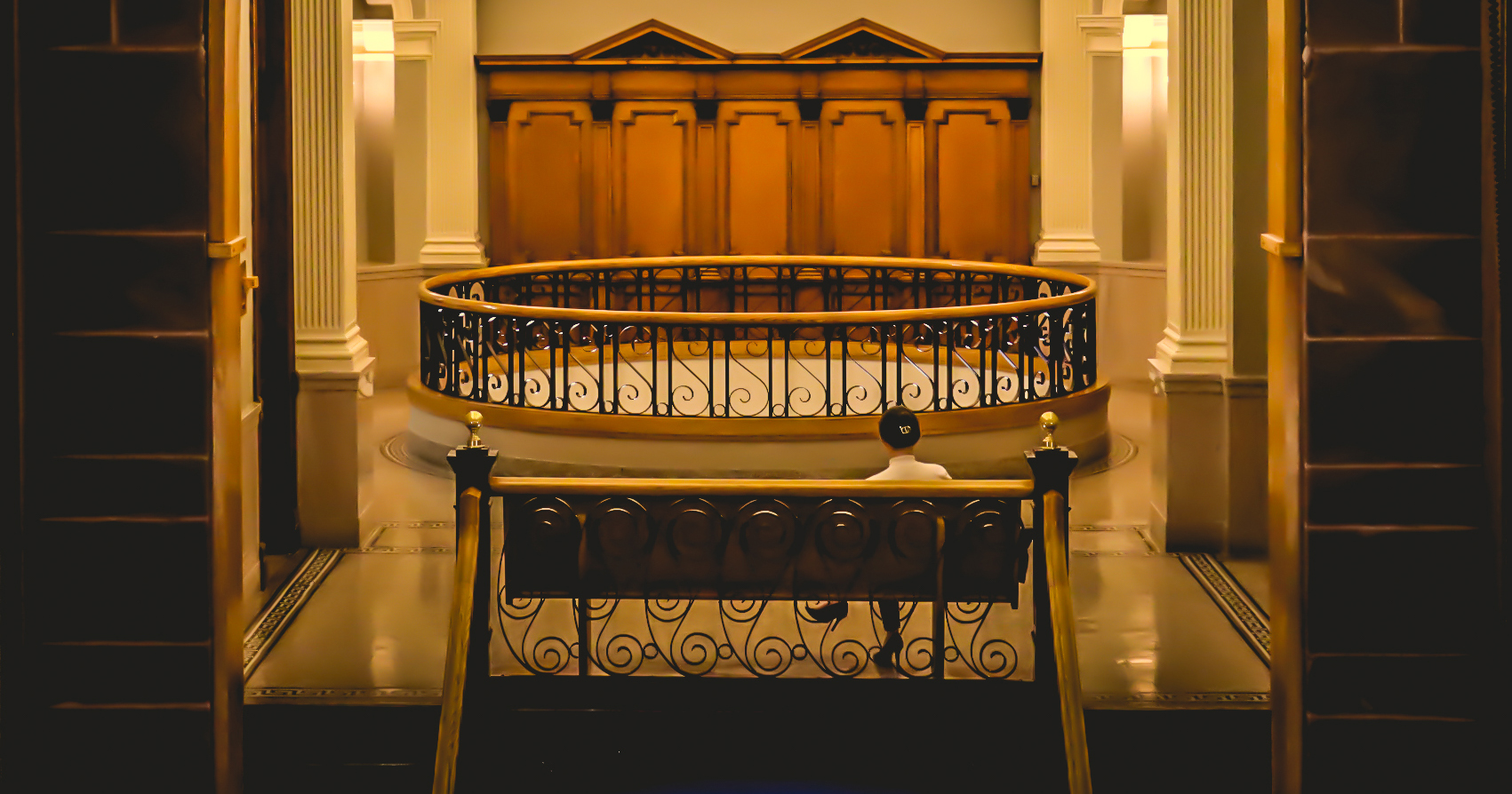 Image of a person sitting on a bench outside of the courtrooms in the Cass County Courthouse