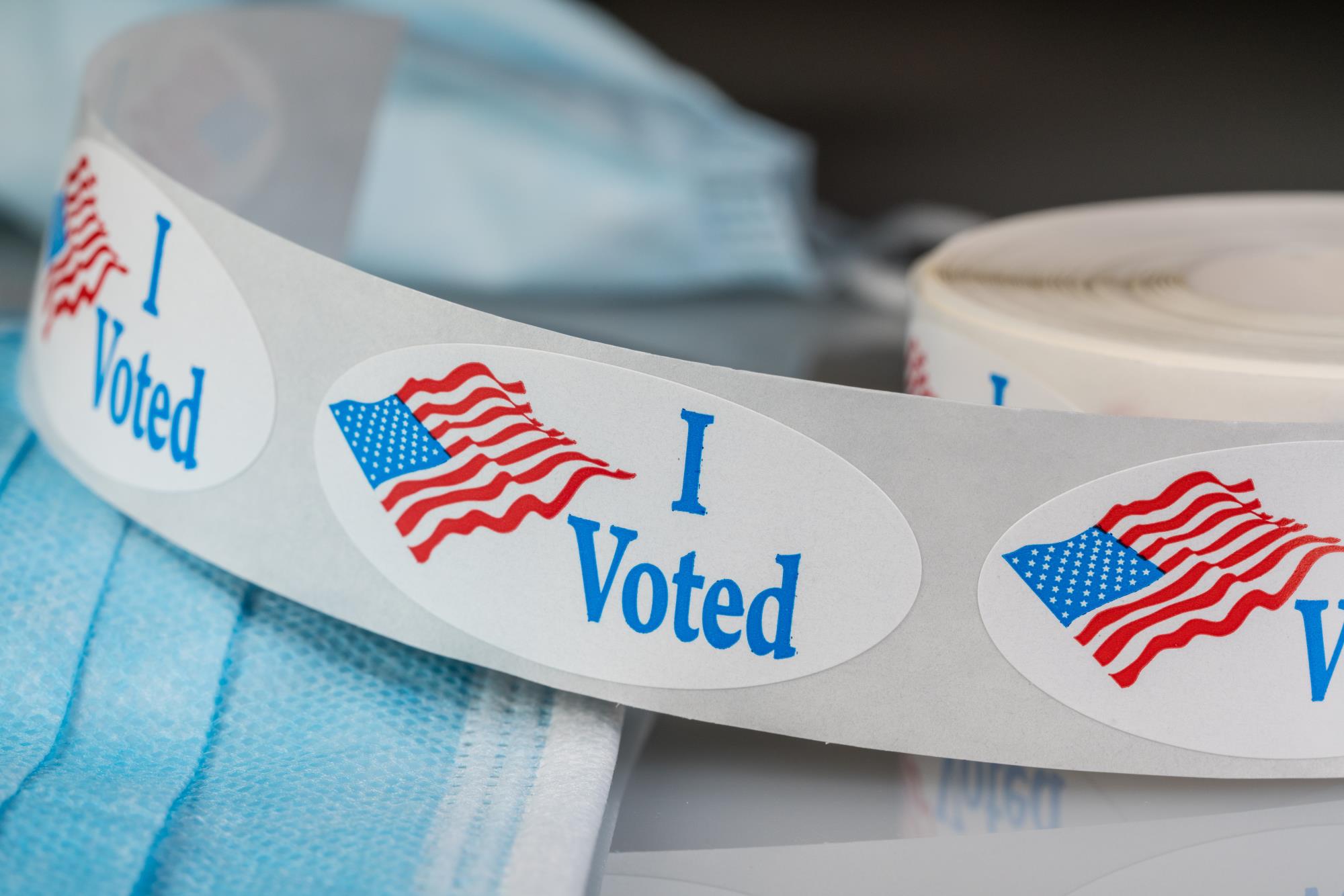 Image of an I Voted sticker with an American Flag - click for more information on upcoming elections.