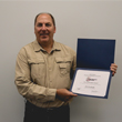 Thumbnail image of Emergency Manager Jim Prochniak holding his Achievement Award from the North Dakota Emergency Management Association